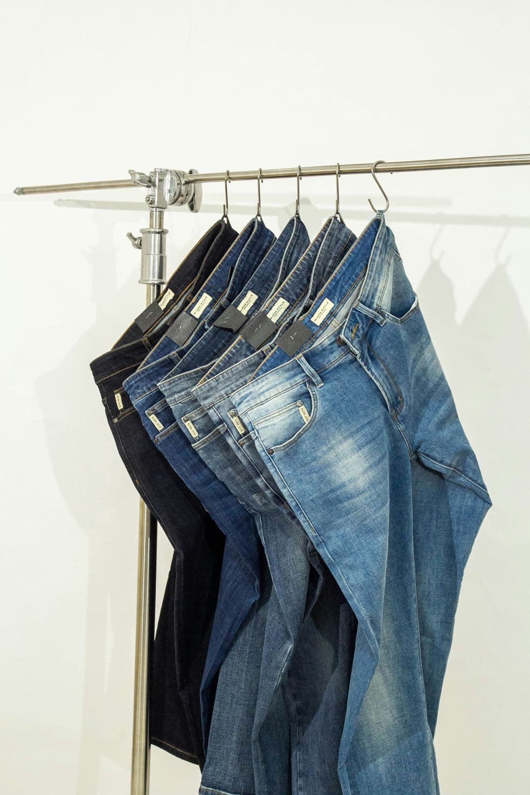 Denim jeans in washes from dark rinse to light blue on a rail