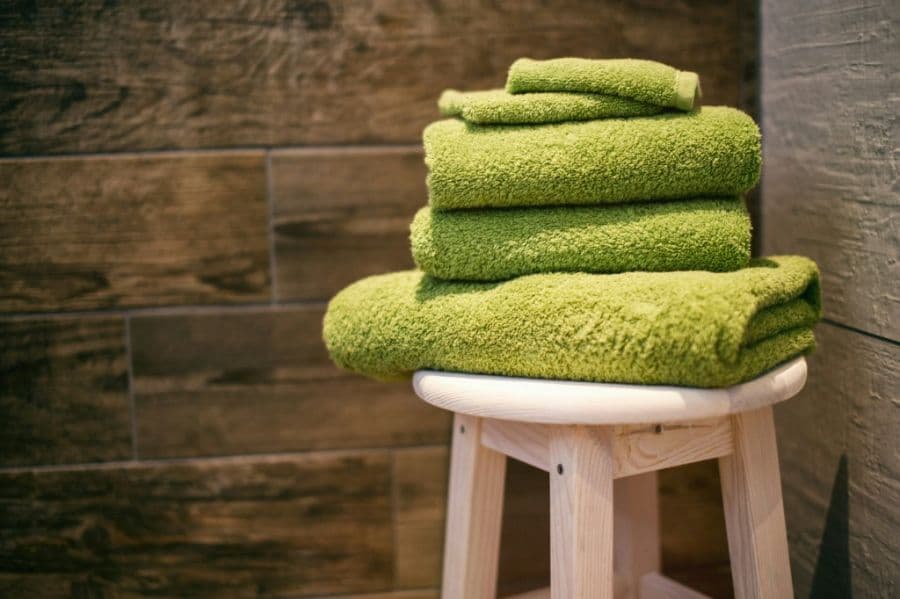 3-piece towel set stacked on a wooden stool