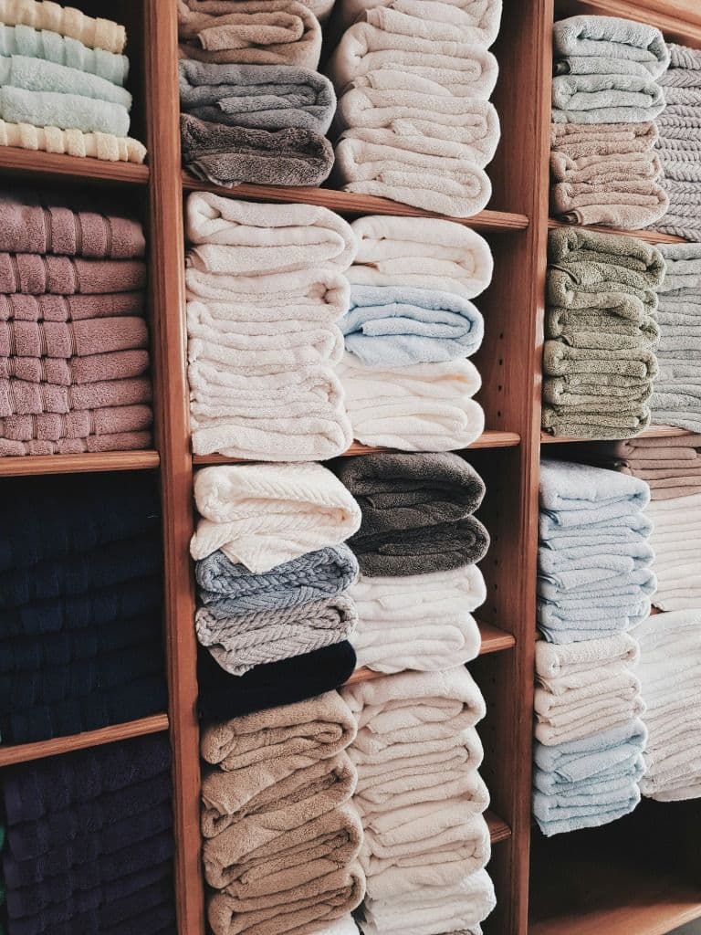 Linen closet showing organized towel stacks in various colours